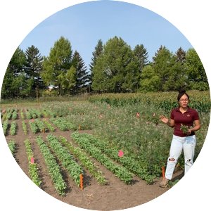 A photo of Jessica Barbosa Oliveira presenting in a field of crops 